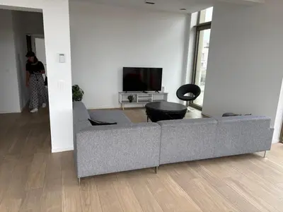 a living room with a couch and a tv at Top floor luxury with spectacular water views in Brussels