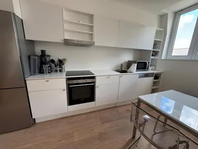 a kitchen with white cabinets and a stove top oven at Wonderful Brussels in Uccle in Brussels