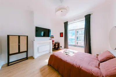a bedroom with a red bed and a television at Slow Moments in Brussels in Brussels