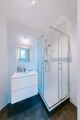 a bathroom with a glass shower and a sink at Slow Moments in Brussels in Brussels