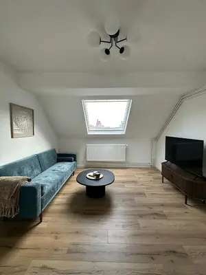 a living room with a blue couch and a table at 3- Duplex Lumineux au coeur d'Ixelles in Brussels