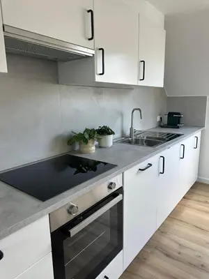 a kitchen with white cabinets and a sink at 3- Duplex Lumineux au coeur d'Ixelles in Brussels