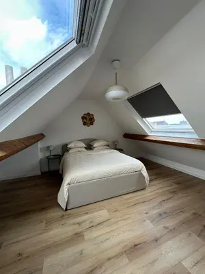 a bedroom with a bed and a large window at 3- Duplex Lumineux au coeur d'Ixelles in Brussels