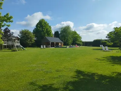 a large field with a playground and a house at Il Giardino Segreto in Waterloo