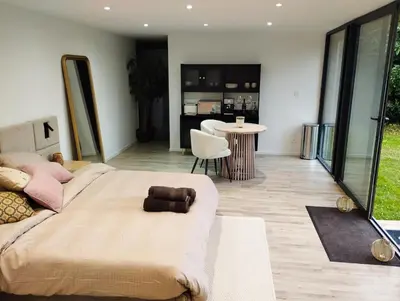 a bedroom with a large bed and a living room at Il Giardino Segreto in Waterloo