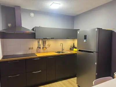 a kitchen with a stainless steel refrigerator and a sink at Luxurious apartment in Auderghem in Brussels