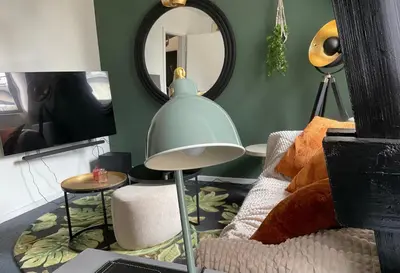 a living room with a lamp and a couch and a mirror at Appartement historisch centrum Antwerpen in Antwerp