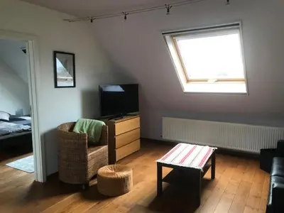 a living room with a tv and a chair and a table at Fokus time out 2 in Dessel