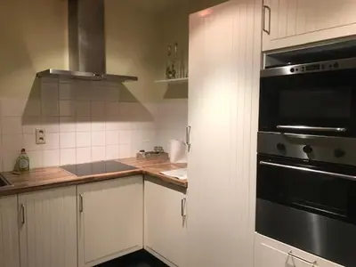 a kitchen with white cabinets and a black oven at Fokus time out 2 in Dessel