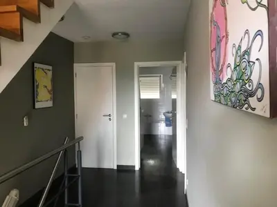 a hallway with a staircase and a painting on the wall at Fokus time out 2 in Dessel