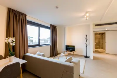 a living room with a couch and a tv at Tower Hotel Aalst in Aalst