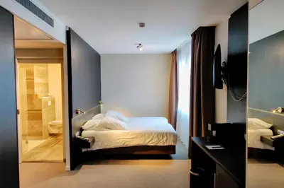 a hotel room with a bed and a bathroom at Tower Hotel Aalst in Aalst
