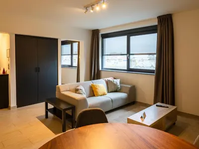 a living room with a couch and a table at Tower Hotel Aalst in Aalst