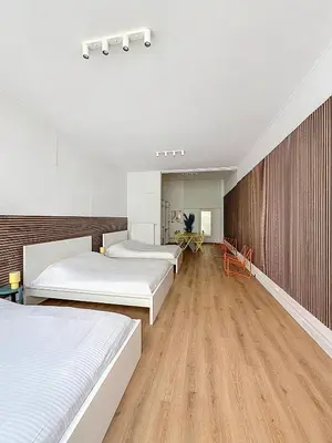 a bedroom with three beds and a wooden wall at Central Spot - Louise in Brussels