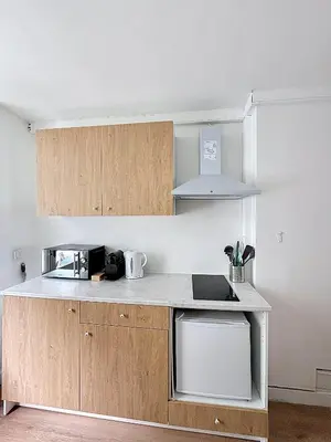 a kitchen with wooden cabinets and a counter top at Central Spot - Louise in Brussels