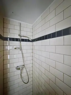 a shower in a bathroom with white tiles at Central Spot - Louise in Brussels