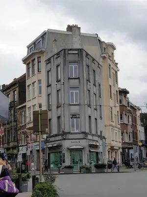 a tall building on a city street with people walking around at Studios - European Quarter in Brussels