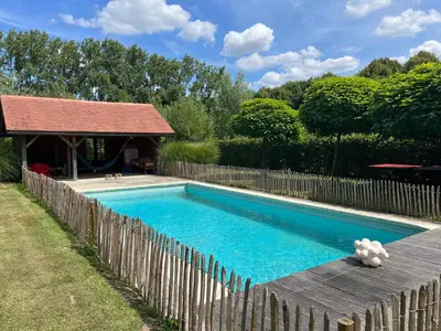 a swimming pool next to a wooden fence at Le Paddock by Ernesst in Lubbeek