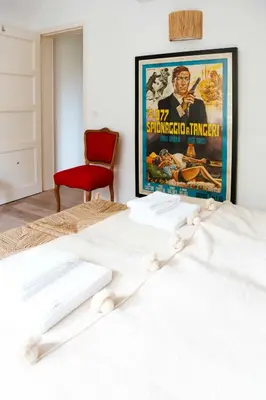 a bed with a movie poster on the wall at Le Paddock by Ernesst in Lubbeek