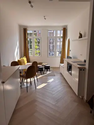 a kitchen and living room with a table and chairs at Studio Miravelle in Antwerp