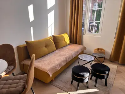 a living room with a couch and some chairs at Studio Miravelle in Antwerp