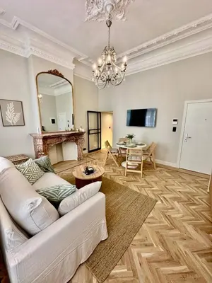 a living room with a white couch and a chandelier at charm and comfort in Brussels