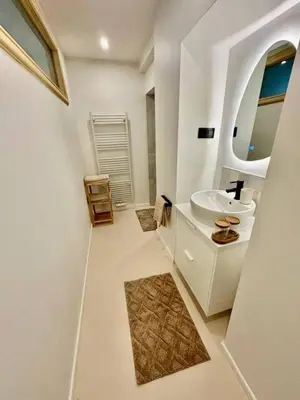a white bathroom with a sink and a mirror at charm and comfort in Brussels