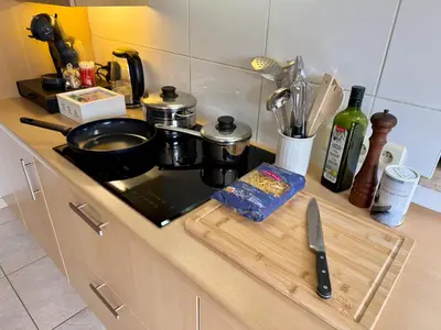 a kitchen counter with a stove and a cutting board at 3BR Villa with Big Garden, Ping-Pong, Cinema, Bath in Ghent
