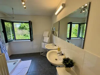 a bathroom with two sinks and a mirror at 3BR Villa with Big Garden, Ping-Pong, Cinema, Bath in Ghent