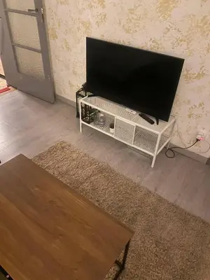 a flat screen tv on a white stand in a living room at Big beautiful appartement in center of Antwerpen in Antwerp