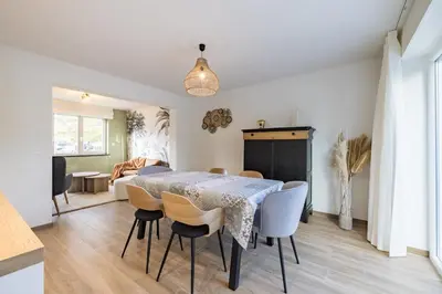 a dining room and living room with a table and chairs at Adorable maison 3ch proche de Bruxelles-Tervuren in Tervuren