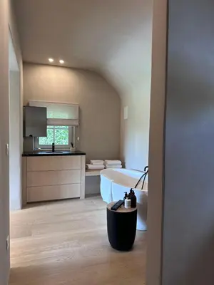 a large bathroom with a tub and a kitchen at De Middenblijk in Turnhout