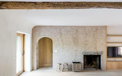 a living room with a brick wall and a fireplace at De Middenblijk in Turnhout