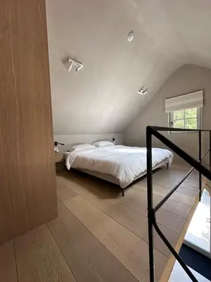 a bedroom with a bed and a staircase in it at Gastenverblijf De Middenblijk in Turnhout