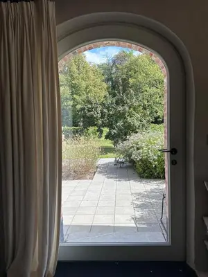 an arched window with a view of a patio at Gastenverblijf De Middenblijk in Turnhout