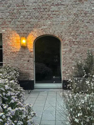 a brick building with a window with a light on it at Gastenverblijf De Middenblijk in Turnhout