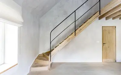 a staircase in a white room with a wooden door at Gastenverblijf De Middenblijk in Turnhout
