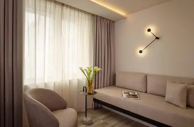 a living room with a couch and a chair and a window at Courtyard by Marriott Ghent in Ghent
