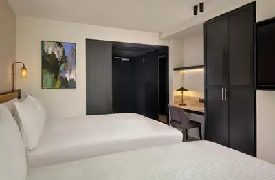 a hotel room with two beds and a desk at Courtyard by Marriott Ghent in Ghent