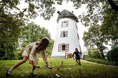 two girls playing in front of a lighthouse at De Zwarte Molen - erfgoedlogie in het groen in Lille