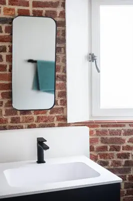a bathroom with a white sink and a mirror at De Zwarte Molen - erfgoedlogie in het groen in Lille