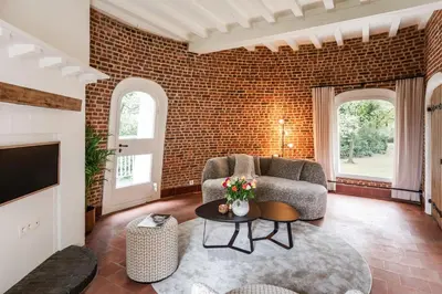 a living room with a brick wall at De Zwarte Molen - erfgoedlogie in het groen in Lille