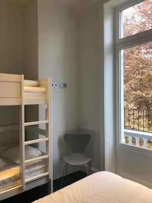 a bedroom with a bunk bed and a chair and a window at Rietveldhouse Gent in Ghent