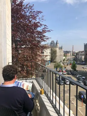 a man sitting on a balcony reading a magazine at Rietveldhouse Gent in Ghent