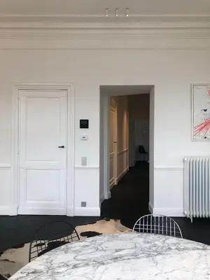a white room with a bed and two chairs at Rietveldhouse Gent in Ghent