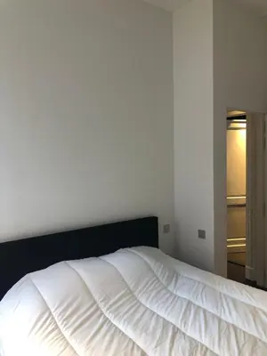 a white bed with a black headboard in a bedroom at Rietveldhouse Gent in Ghent