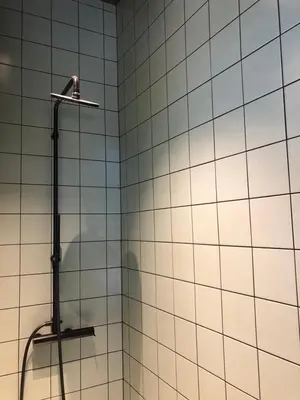 a shower with white tiled walls and a shower head at Rietveldhouse Gent in Ghent