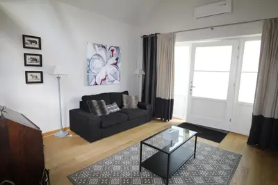 a living room with a black couch and a glass table at Casa Terlinden in Brussels