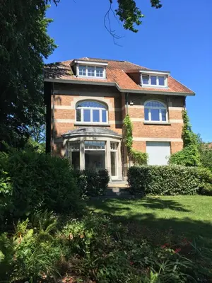 a large brick house with windows on a lawn at Casa Terlinden in Brussels