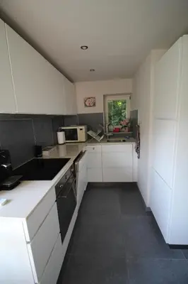 a kitchen with white cabinets and a counter top at Casa Terlinden in Brussels